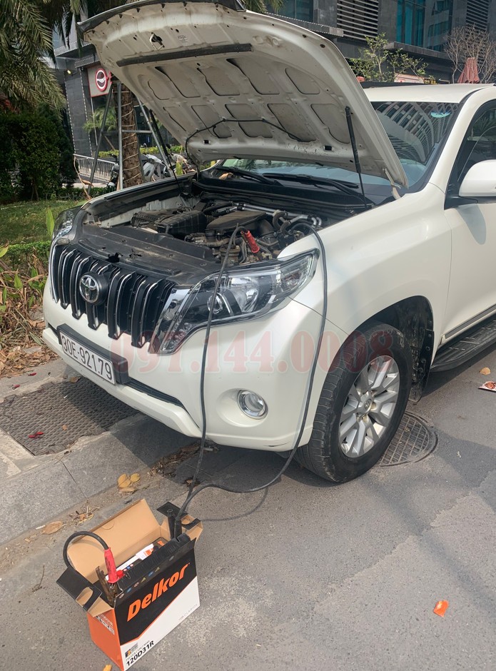 Kỹ thuật viên đang kiểm tra hoặc thay thế bình ắc quy cho xe ô tô
