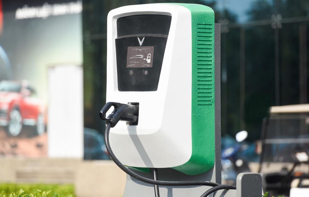 Xe ô tô điện đang kết nối với trụ sạc, minh họa quy trình sạc pin để tối ưu quãng đường xe ô tô di chuyển