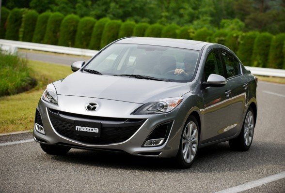 Một chiếc Mazda3 Sport màu đỏ đời 2011 đang di chuyển, cho thấy thiết kế thể thao và khả năng lái thú vị, phù hợp làm xe ô tô cho sinh viên