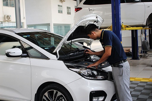 Kỹ thuật viên kiểm tra gầm xe ô tô cũ trên cầu nâng