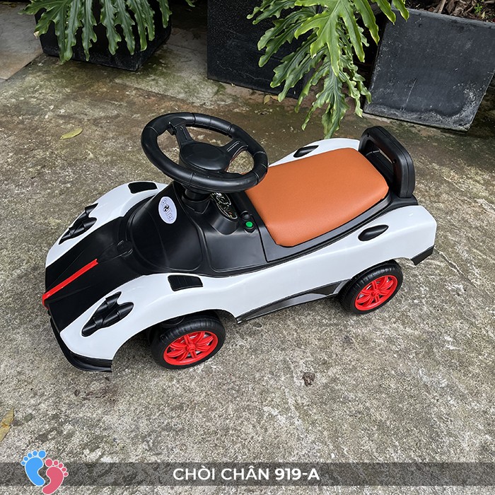 Bé tập lái xe chòi chân ô tô trong nhà