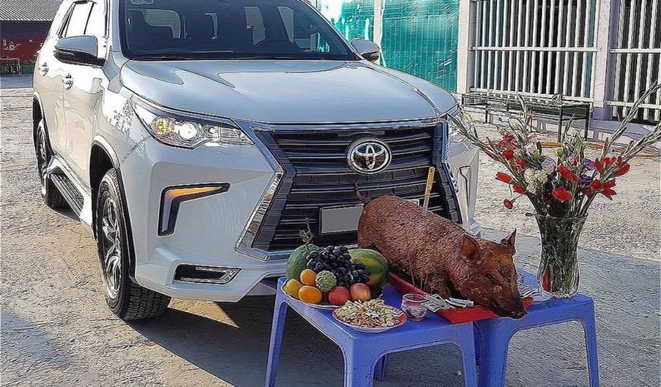 Thực hiện nghi lễ cúng xe ô tô hàng tháng ngoài trời
