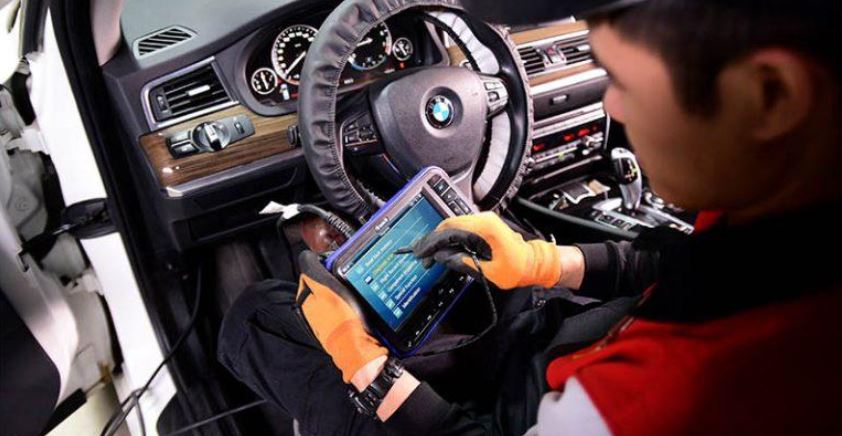 Kỹ thuật viên đang thực hiện bảo dưỡng xe ô tô tại gara