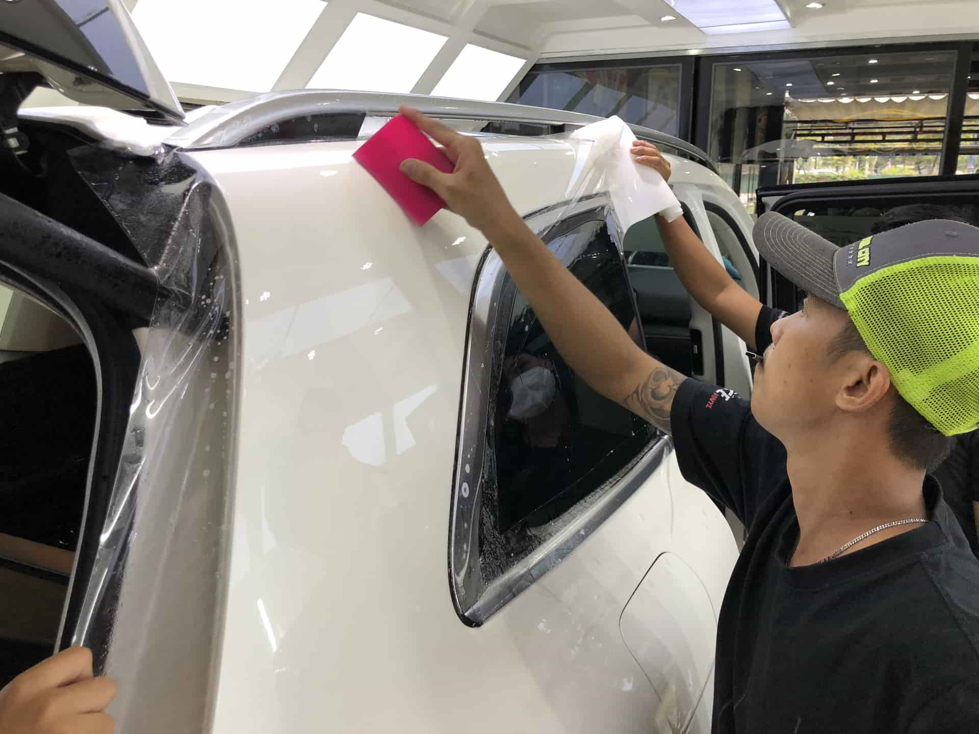 Ảnh xe ô tô màu đỏ đang được dán phim PPF trong suốt, minh họa công dụng của phim PPF trong bảo vệ sơn xe