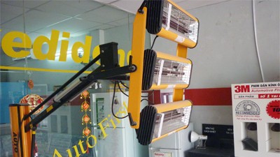 Kỹ thuật viên sử dụng đèn hồng ngoại để sấy sơn