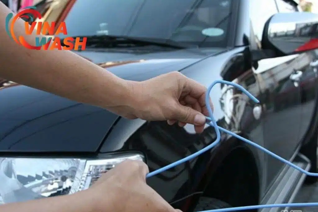 Dùng móc treo quần áo kim loại để mở khóa cửa xe