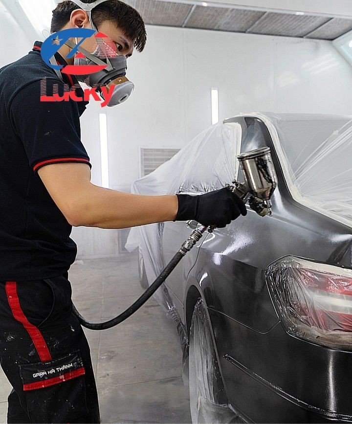 Kỹ thuật viên đang thực hiện phun sơn xe ô tô chuyên nghiệp