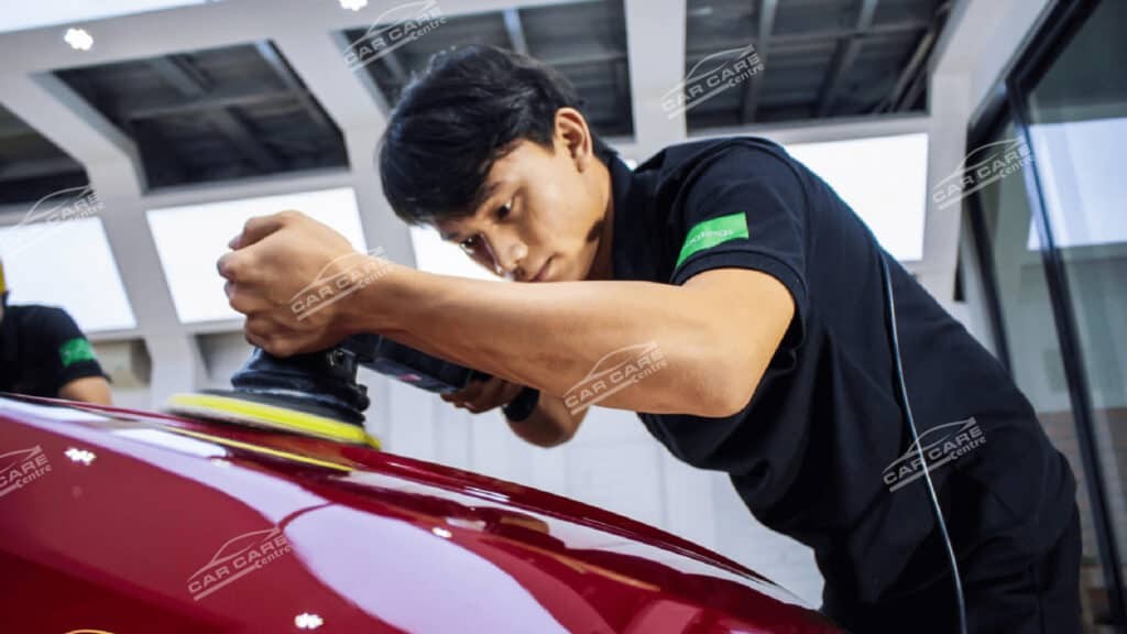 Kỹ thuật viên đánh bóng xe ô tô màu đỏ chuyên nghiệp