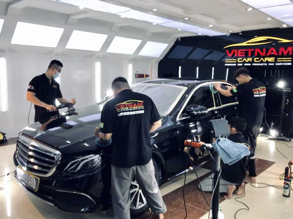 Đội ngũ kỹ thuật viên đánh bóng xe ô tô tại trung tâm chăm sóc xe
