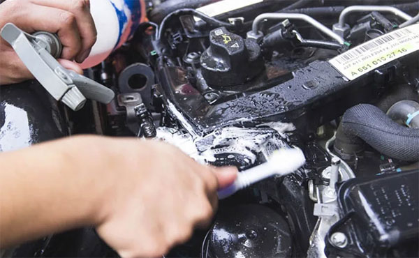 Dùng bàn chải chà sạch vết bẩn trong khoang máy ô tô