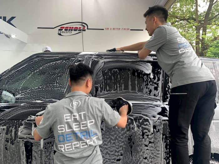 Hình ảnh chăm sóc xe ô tô, bao gồm tẩy bụi sơn, tại trung tâm dịch vụ