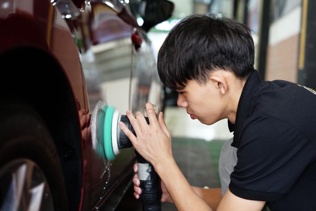 Kỹ thuật viên chuyên nghiệp đang thực hiện đánh bóng xe ô tô