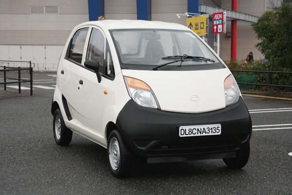 Một chiếc Tata Nano màu đỏ đang di chuyển trên đường
