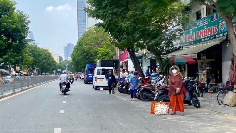 Khu vực có ô đỗ xe thu phí trên đường Nguyễn Cư Trinh, Quận 1 thường xuyên bị các cơ sở kinh doanh chiếm dụng khiến nhân viên lúng túng trong công tác thu phí và quản lý đậu đỗ xe.