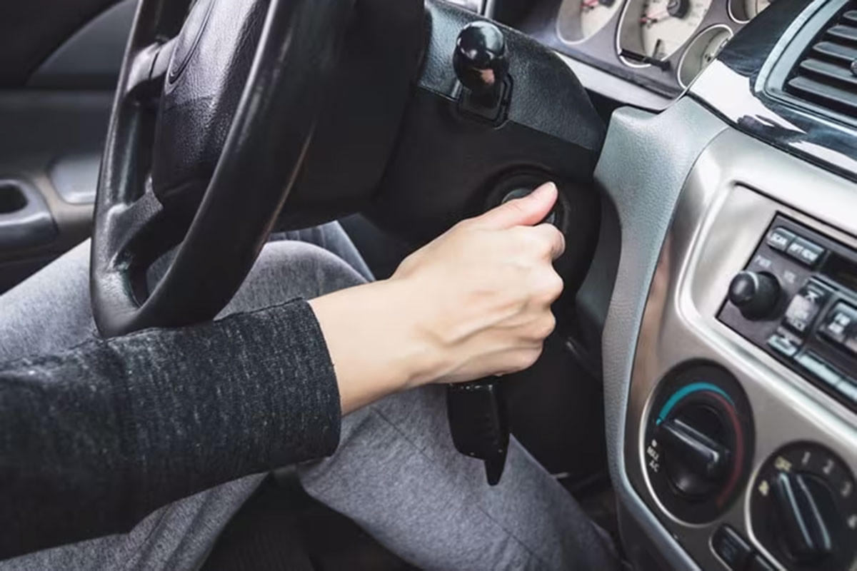 Người lái xe đang vặn chìa khóa khởi động xe ô tô