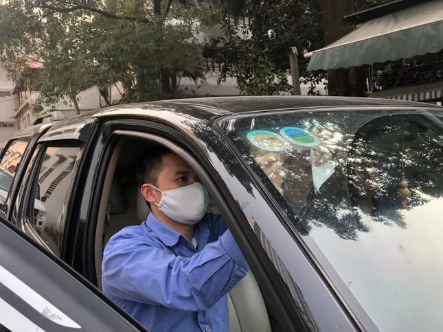 Đăng kiểm viên dán tem đăng kiểm xe ô tô lên kính chắn gió