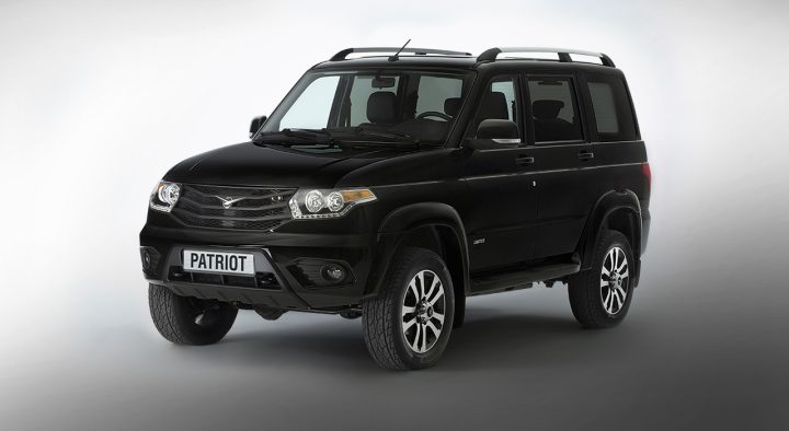 Xe ô tô UAZ Patriot màu trắng đang di chuyển, thể hiện sự kết hợp giữa truyền thống và hiện đại