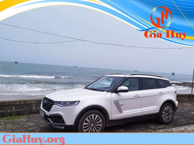 Tổng quan một chiếc xe hơi đang di chuyển trên con đường núi, phong cảnh hùng vĩ của Sapa bao quanh