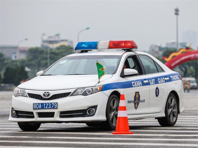 Chiếc xe ô tô công an đang di chuyển trên đường phố, biểu tượng cho an ninh