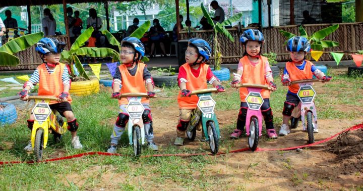 Bé trai chơi xe đạp thăng bằng rèn luyện kỹ năng